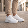 Man wearing STATURE Airlift white height increasing sneakers on a city street